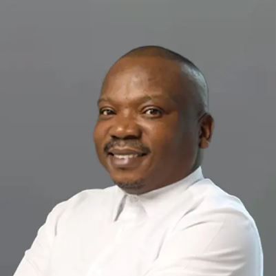 Smiling Black man in a white shirt, against a gray background. Moloko Chepape