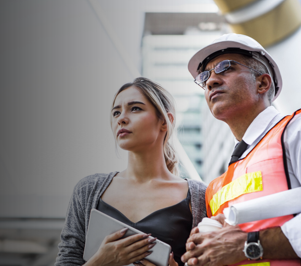 Overhead view of office with four people at desks, some using laptops, papers strewn about.