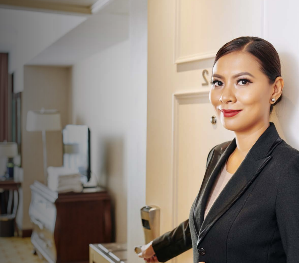 Overhead view of office with four people at desks, some using laptops, papers strewn about.