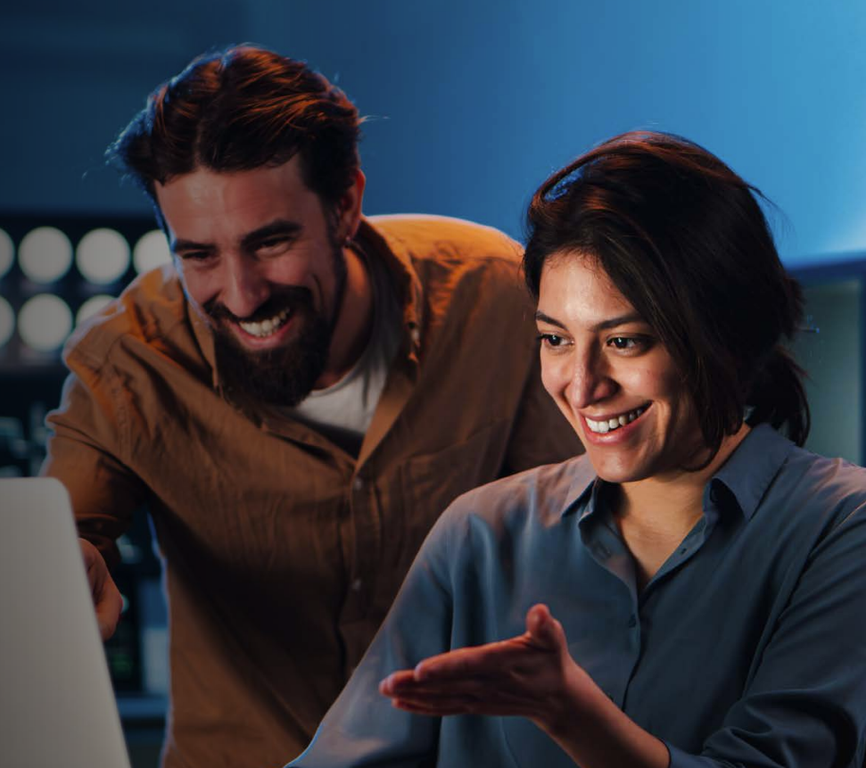 Woman with arms crossed, wearing blue polka dot shirt, standing outside a building, looking directly at the camera.
