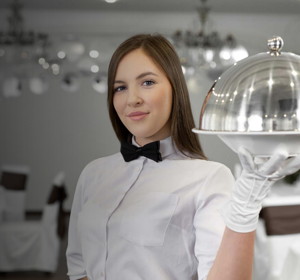 Overhead view of office with four people at desks, some using laptops, papers strewn about.