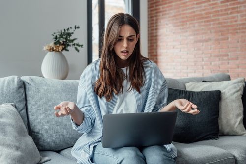 Confused young Woman looking at laptop