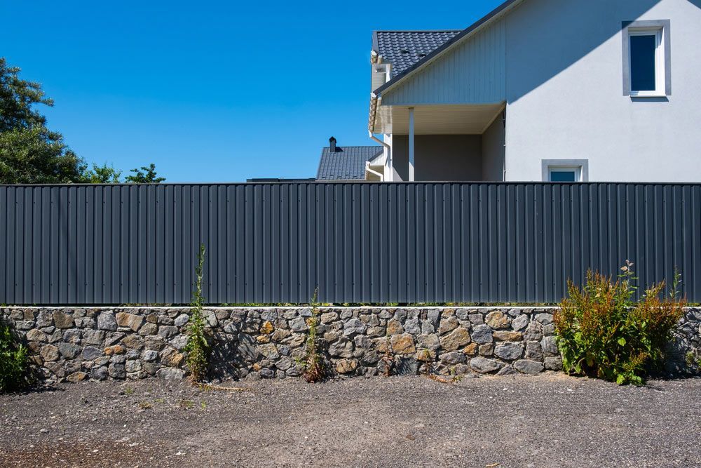 Grey Metal Corrugated Fence in Front of a House — Fencer in Wauchope, NSW
