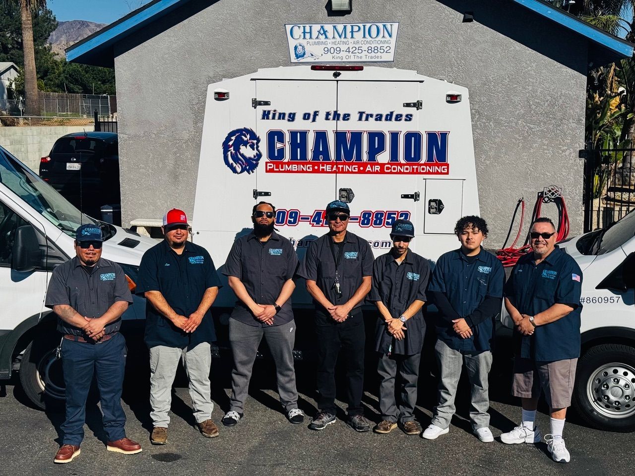 A group of men are posing for a picture in front of a champion van.