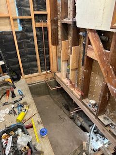 A room with a hole in the floor and a lot of tools on the floor.