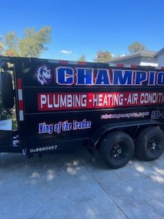 A champion plumbing heating and air conditioning trailer is parked in a driveway.