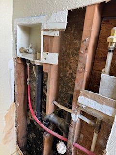 A wall with a lot of pipes coming out of it.