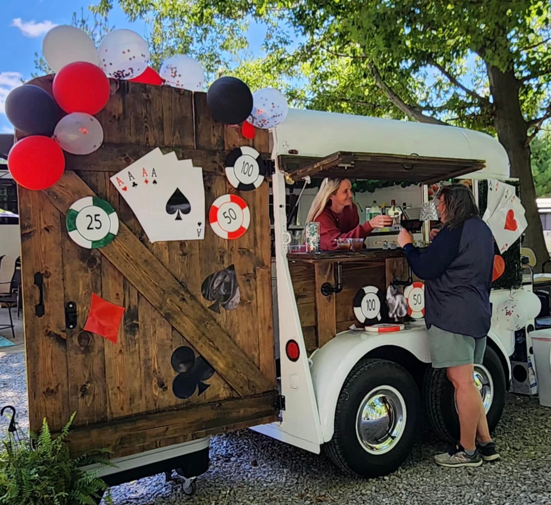 Cocktails on a gold tray, with garnishes and spices in small bowls on a dark surface.