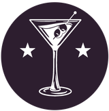 Cocktail glass with olives and stars on a dark purple background.