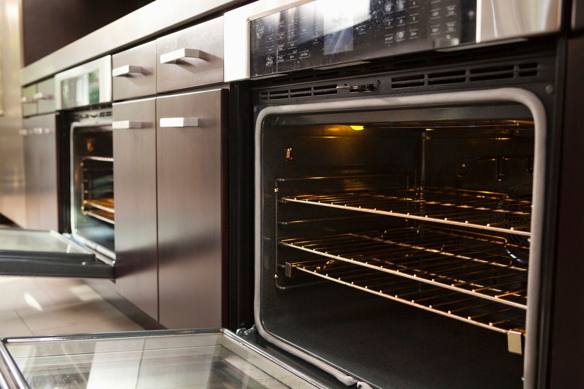 A stainless steel oven with the door open in a kitchen.