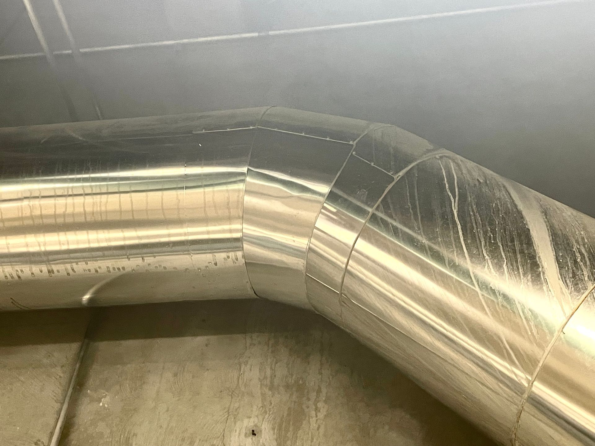 A close up of a stainless steel pipe in a room