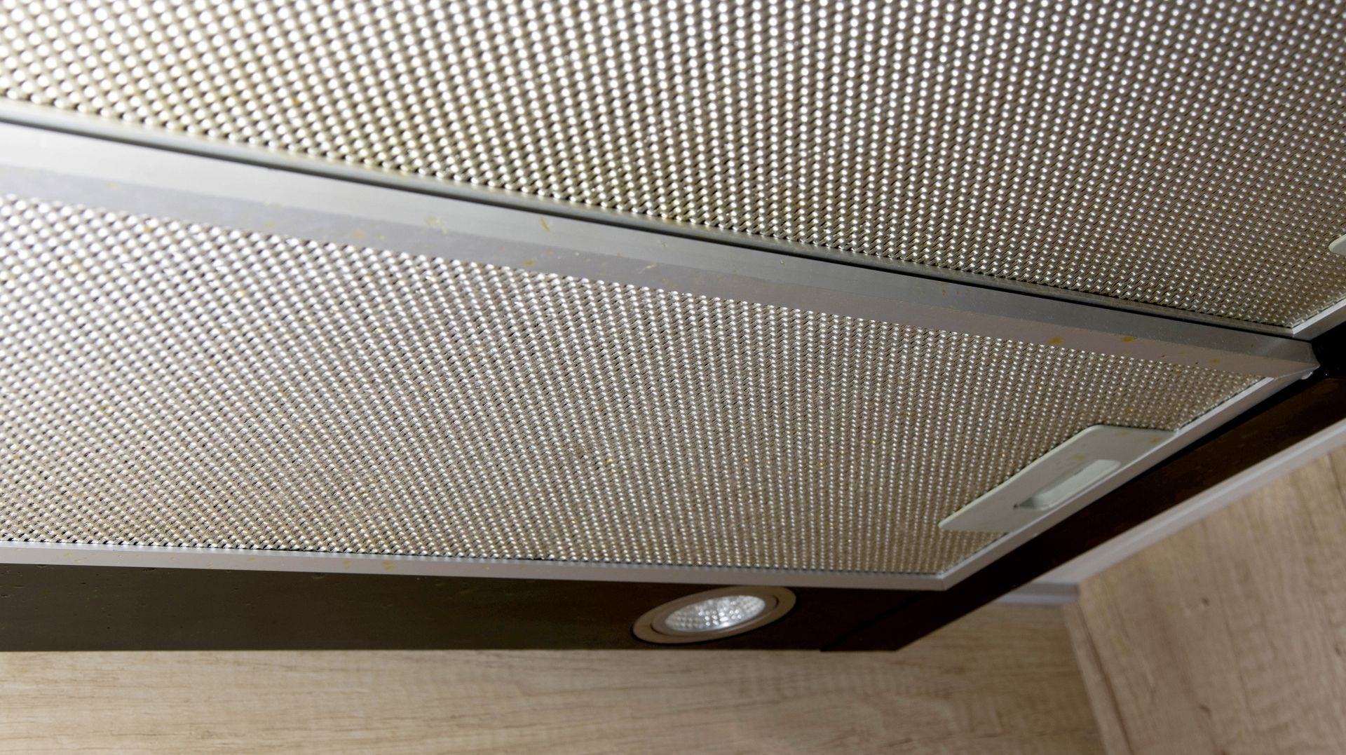 A close up of a ceiling fan in a kitchen.