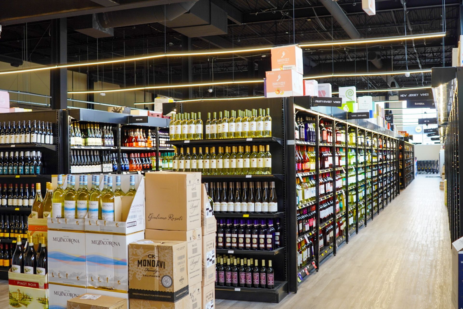 A grocery store aisle filled with lots of wine bottles