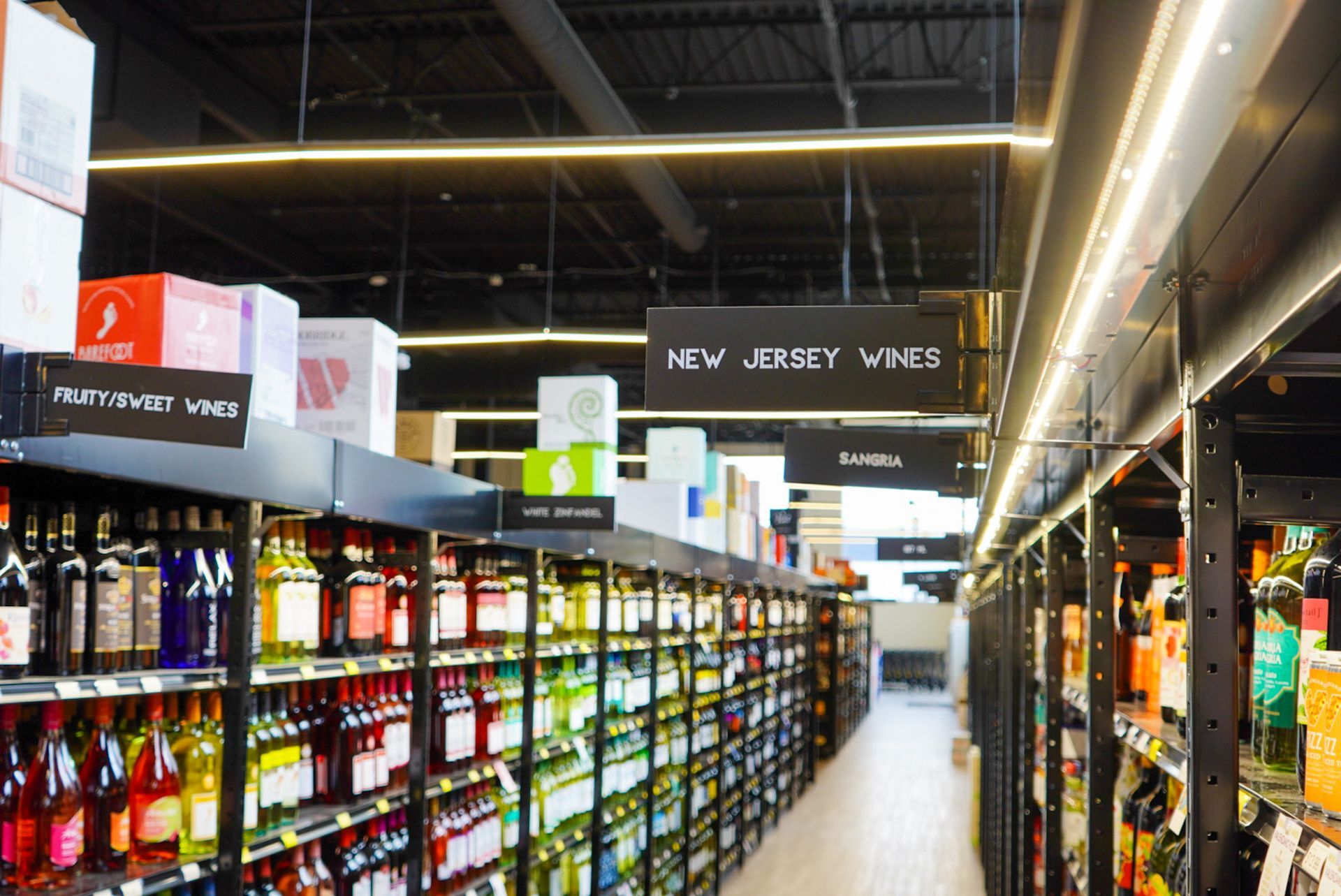 A grocery store aisle filled with lots of bottles of wine.