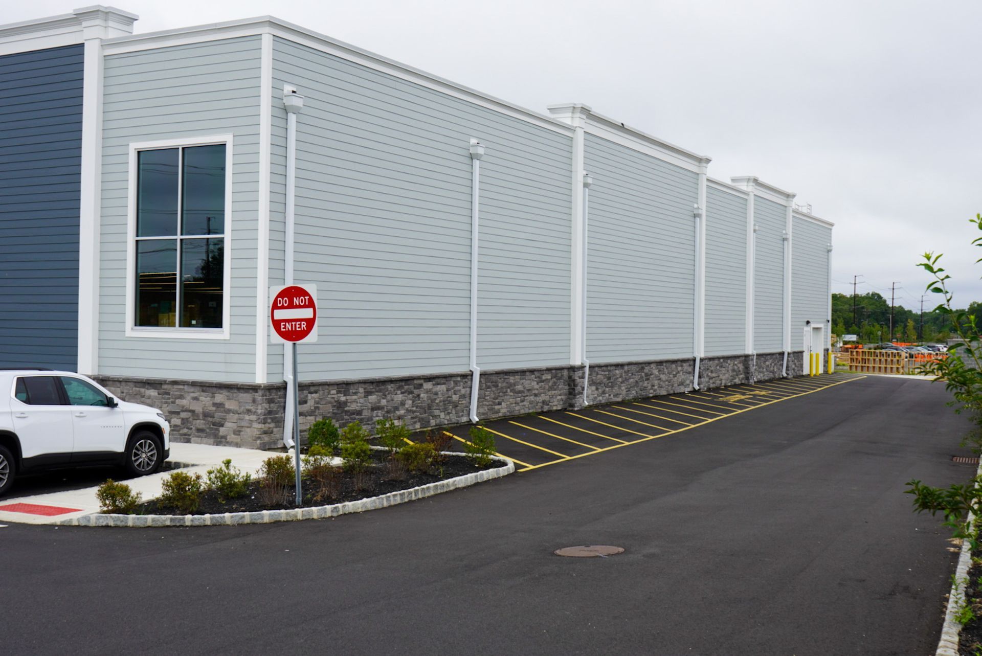 A white truck is parked in front of a building with a do not enter sign.