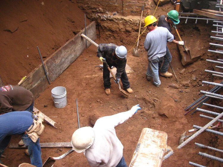 A group of construction workers are digging in the dirt