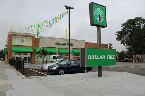 A dollar tree store with cars parked in front of it