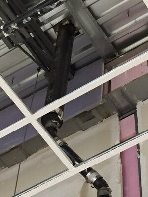 A pipe is hanging from the ceiling of a building
