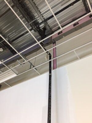 A pipe is hanging from the ceiling of a building.