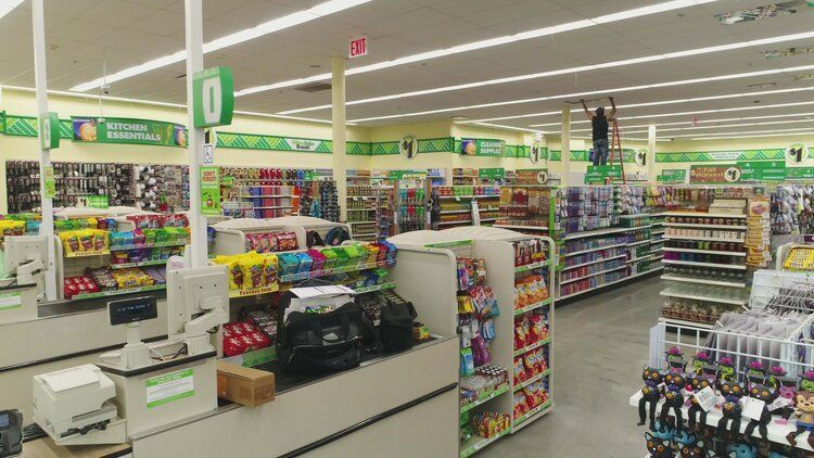 A man is standing on a ladder in a store.