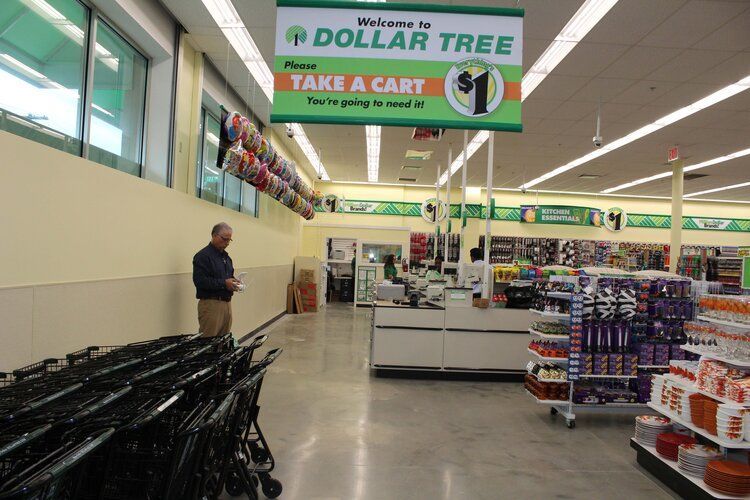 A dollar tree store with a sign that says take a cart
