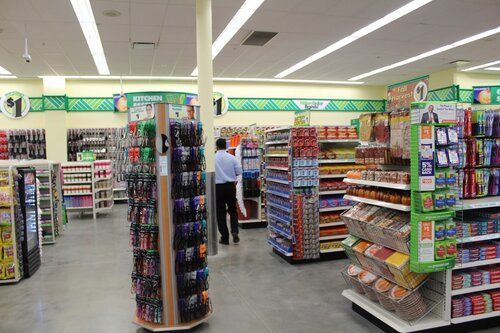 A man is standing in the middle of a store looking at shelves.