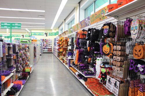 A row of shelves in a store filled with halloween decorations.