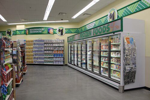 The inside of a grocery store with a frozen foods section.