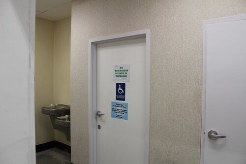 A bathroom with a handicapped sign on the door and a sink.