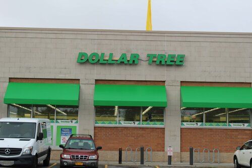 A dollar free store with cars parked in front of it