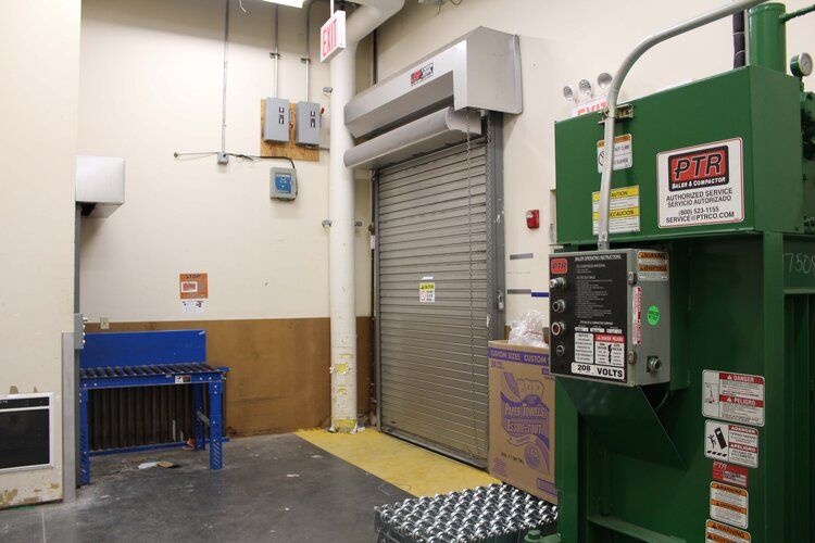 An empty room with a green machine and a sign that says ' a & r ' on it