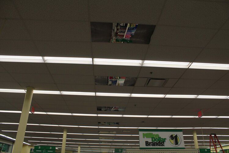 The ceiling of a store with a hole in it and a sign that says $ 1