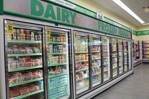 A dairy and frozen food section of a grocery store.