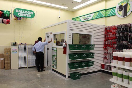 A man is standing in a balloon center in a store.
