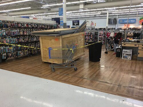 A large wooden box is sitting in a shopping cart in a store.