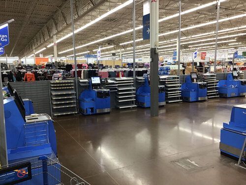 The inside of a walmart store with a lot of cash registers.