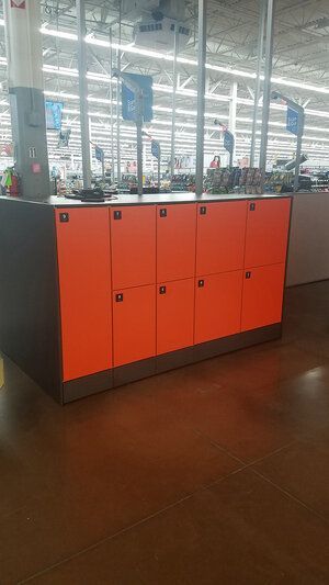 A row of orange lockers in a store.