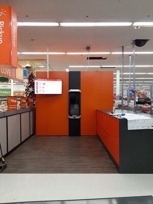 A store with an orange wall and a sign that says pick up