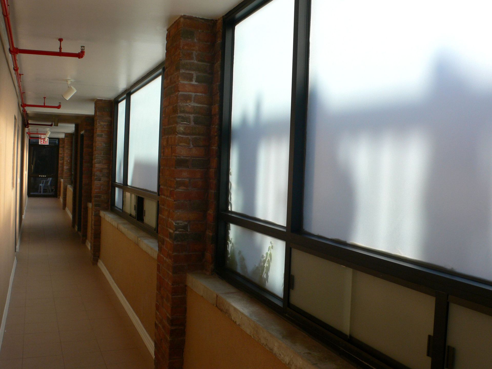A hallway with a lot of windows and a fire hydrant