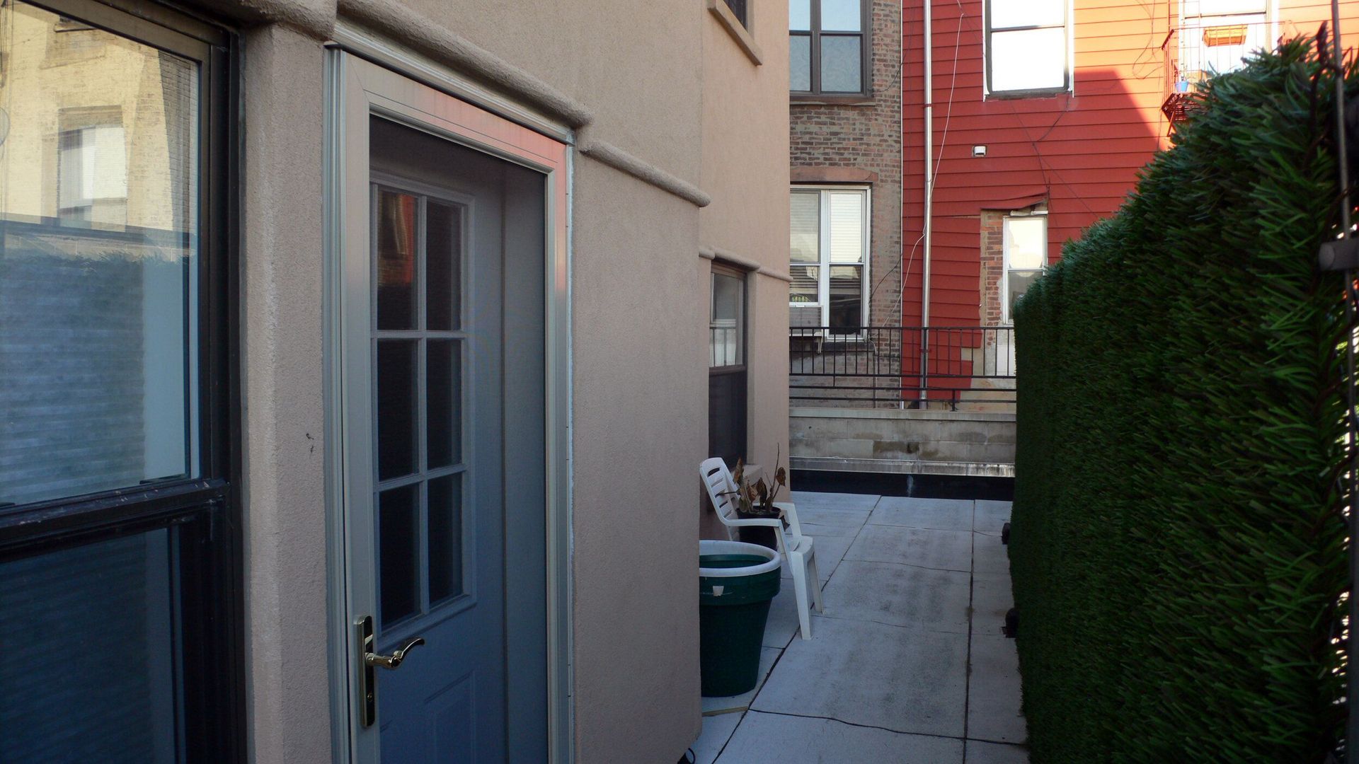 A narrow walkway between two buildings with a brick building in the background