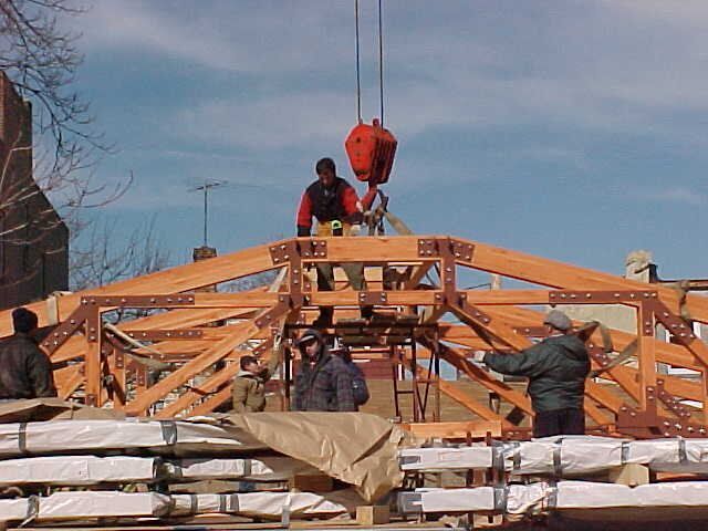 A group of construction workers are working on a wooden structure