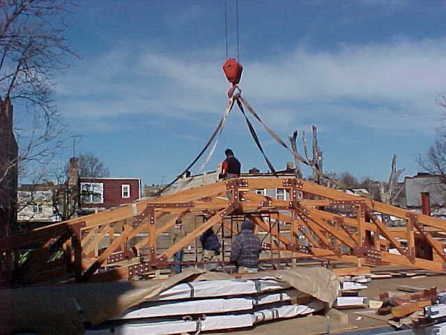 A crane is lifting a wooden structure in the air