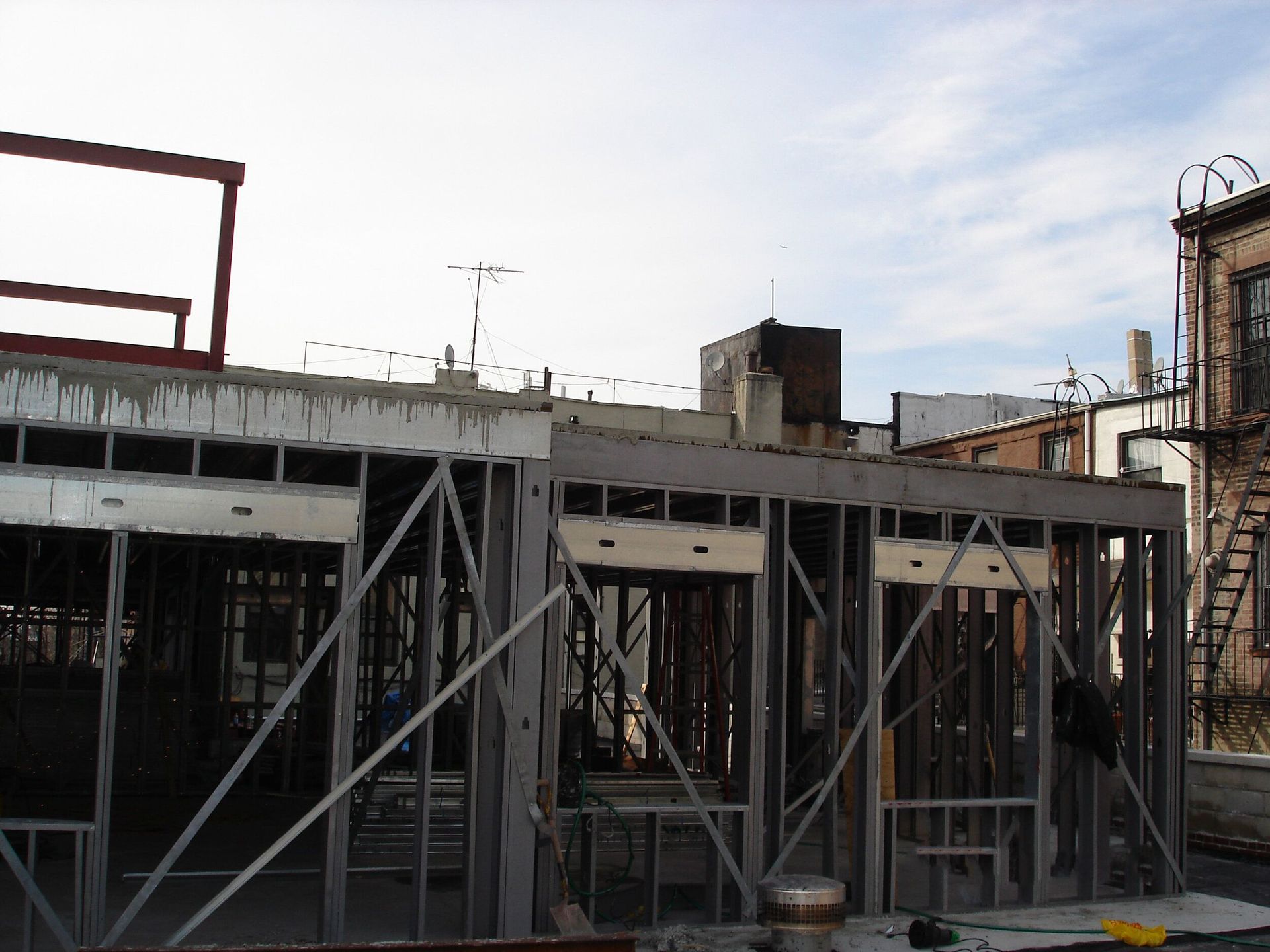 A building under construction with a fire escape in the background