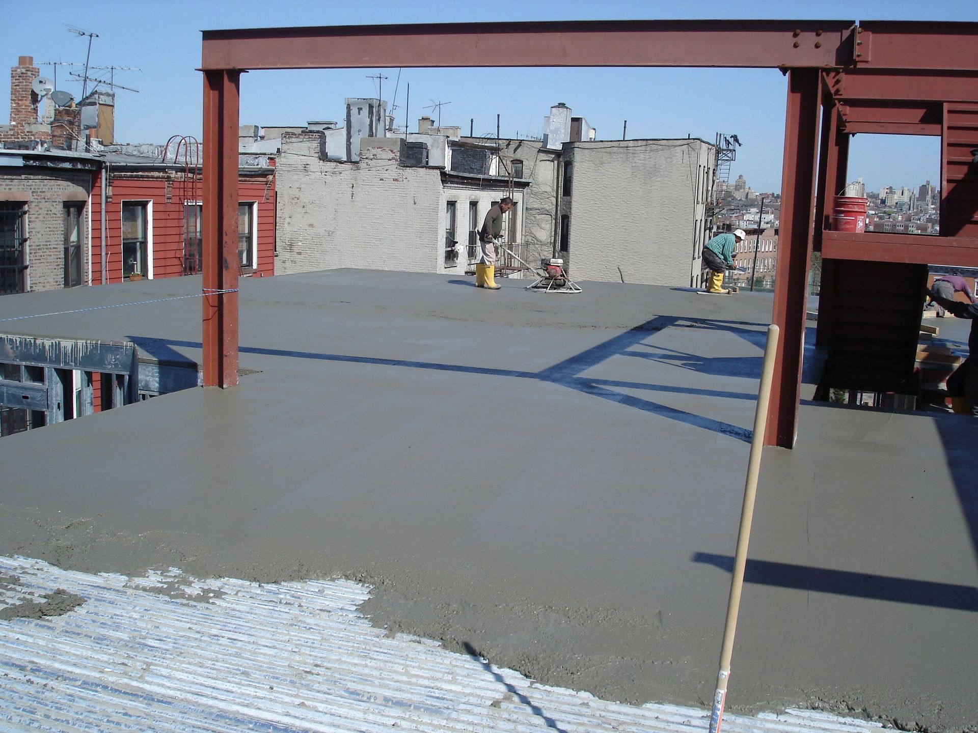 A concrete floor is being poured on top of a building
