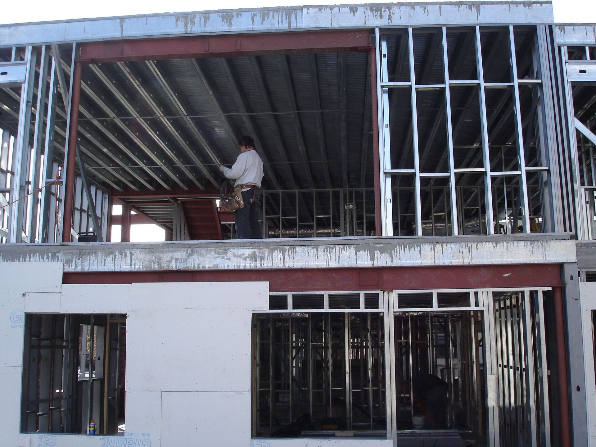 A man is standing on the second floor of a building under construction