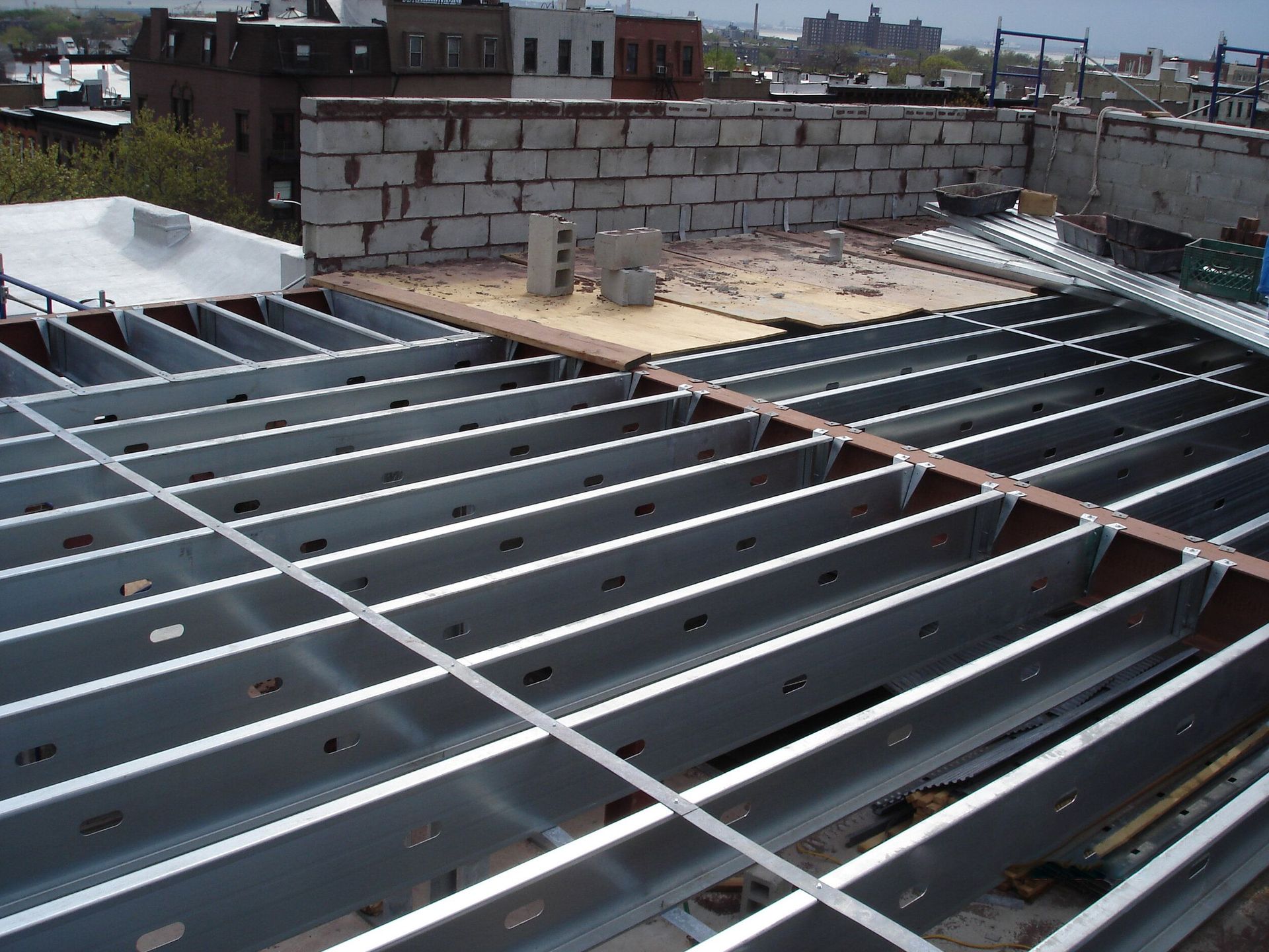 A metal roof with a brick wall in the background