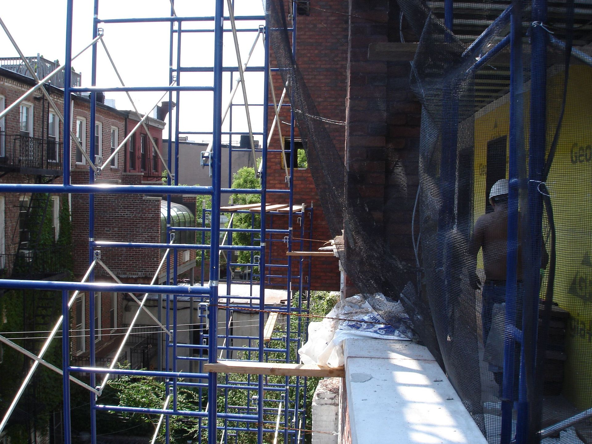 A blue scaffolding is being used to build a building