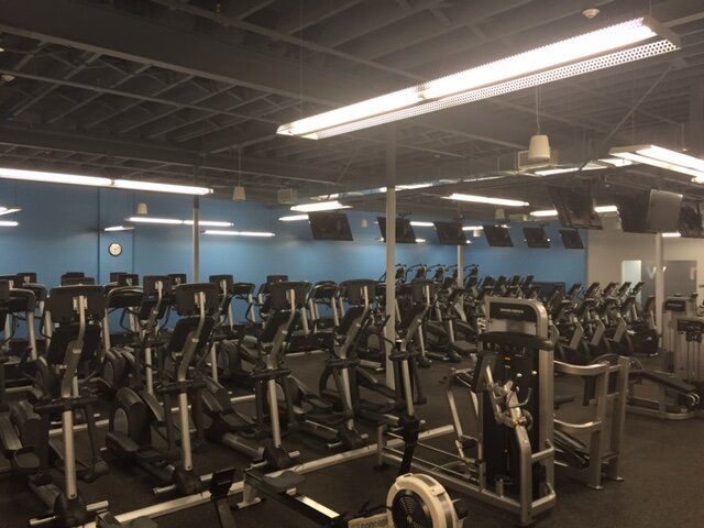 A gym with a lot of treadmills and bikes