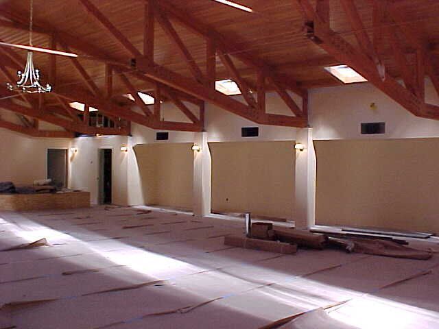 A large room with wooden beams and a chandelier hanging from the ceiling