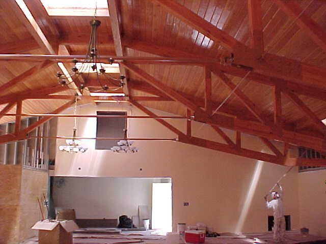 A man is painting the ceiling of a house